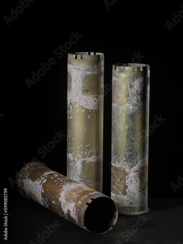 Battle-worn anti-aircraft gun shells on black background