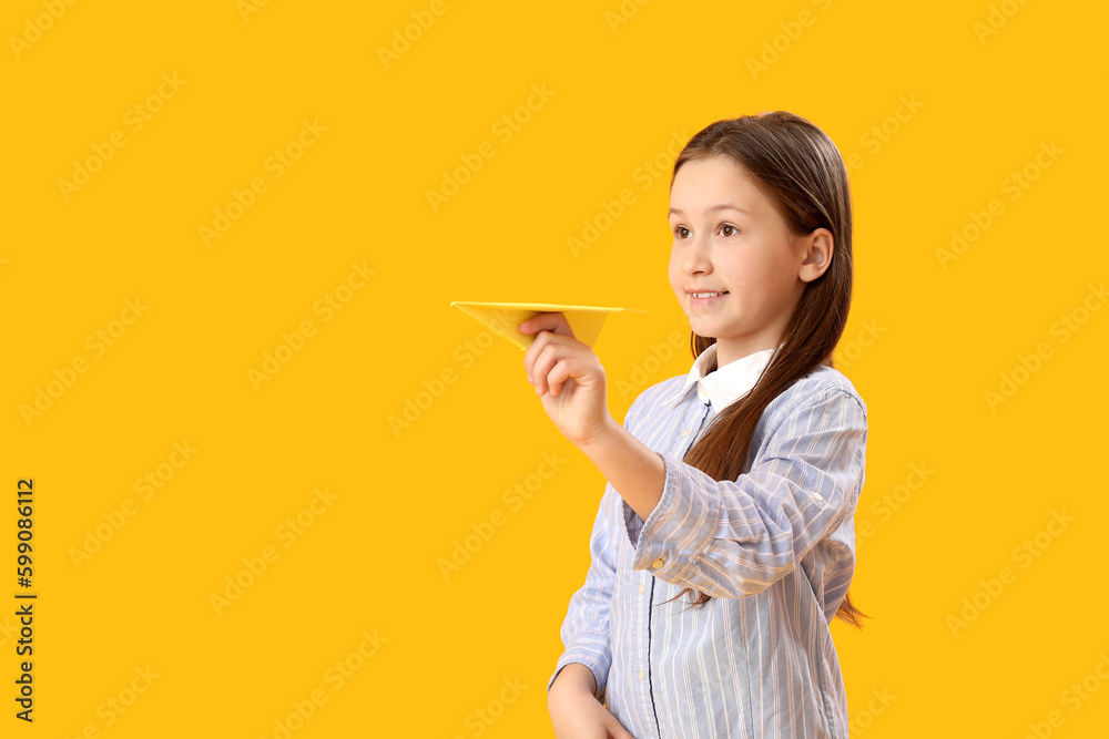 Little girl with paper plane on yellow background. Children's Day celebration Little girl with paper plane on yellow background. Children's Day celebration