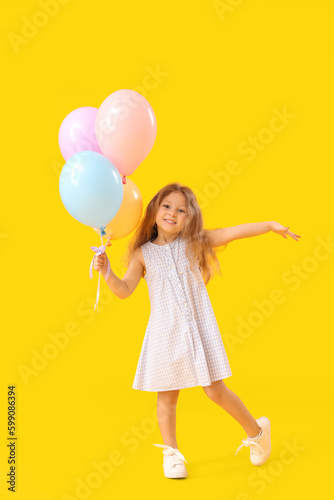 Little girl with balloons on yellow background. Children s Day celebration