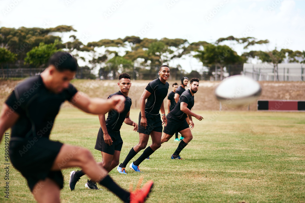 Here comes the kickoff. a group of young men playing a game of rugby. Here comes the kickoff. a group of young men playing a game of rugby.