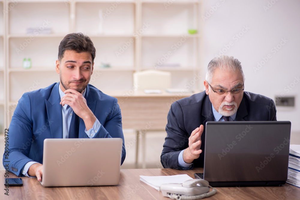 Two male employees working in the office Two male employees working in the office