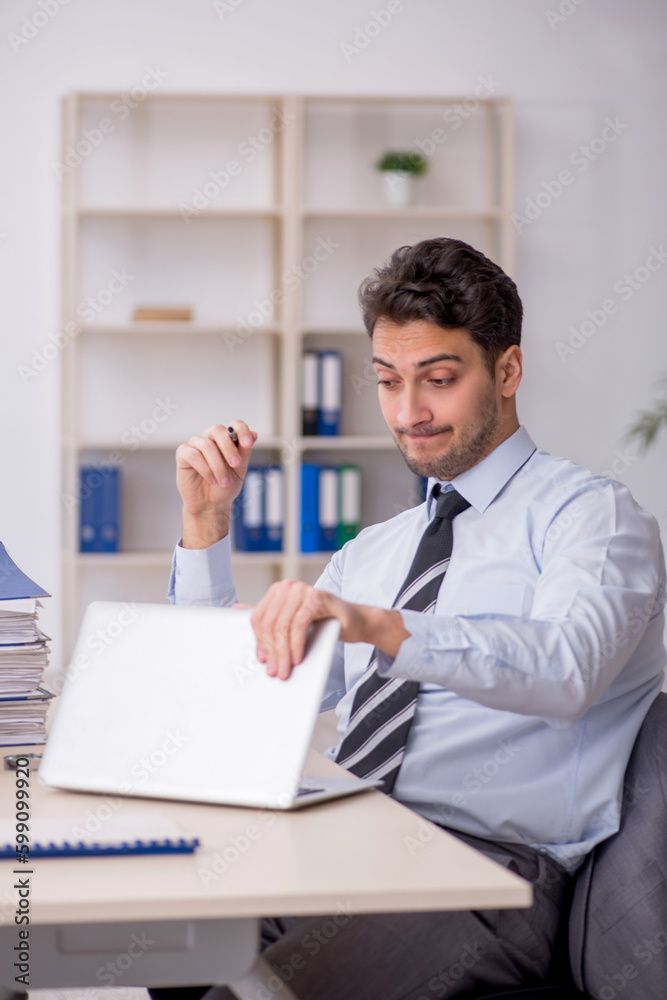 Young male employee working in the office Young male employee working in the office