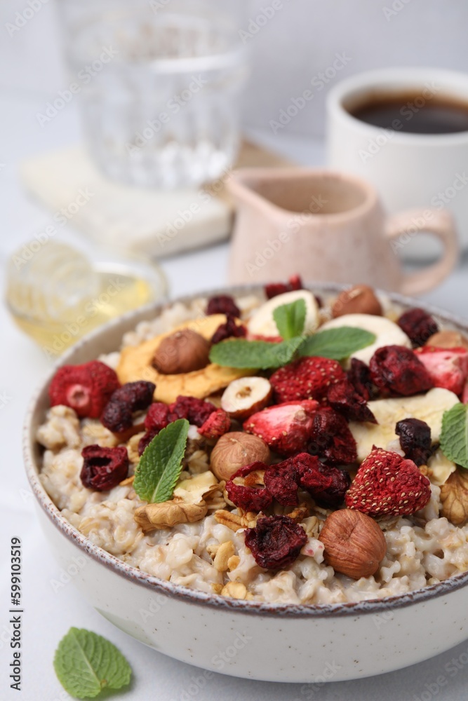 Oatmeal with freeze dried fruits, nuts and mint on white table Oatmeal with freeze dried fruits, nuts and mint on white table