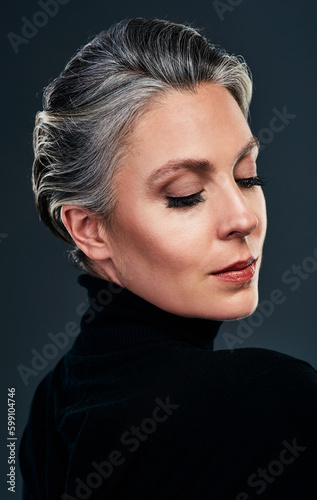 Kindness is grace, and grace is elegance. Studio shot of a beautiful mature woman posing against a dark background.