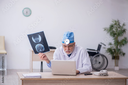 Old male docror otolaryngologist working in the clinic Fototapet