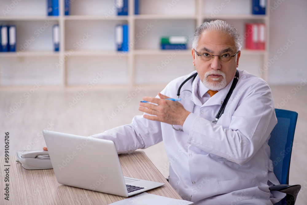 Old male doctor in telemedicine concept
