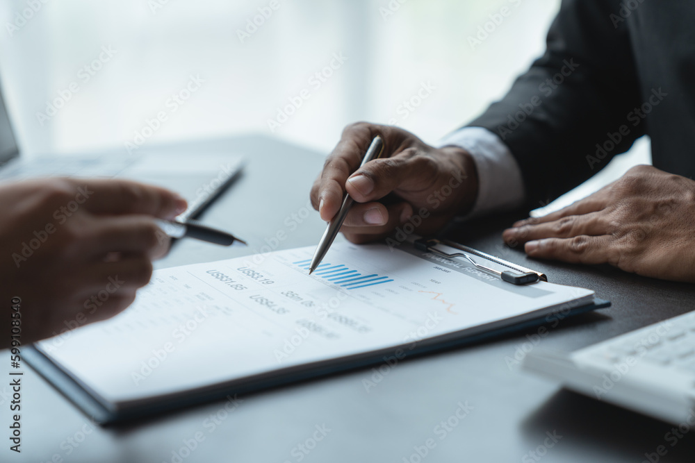 Two business men are analyzing and discussing data on graphs, charts, diagrams and on laptops in business finance to prepare to explain at a meeting. Two business men are analyzing and discussing data on graphs, charts, diagrams and on laptops in business finance to prepare to explain at a meeting.