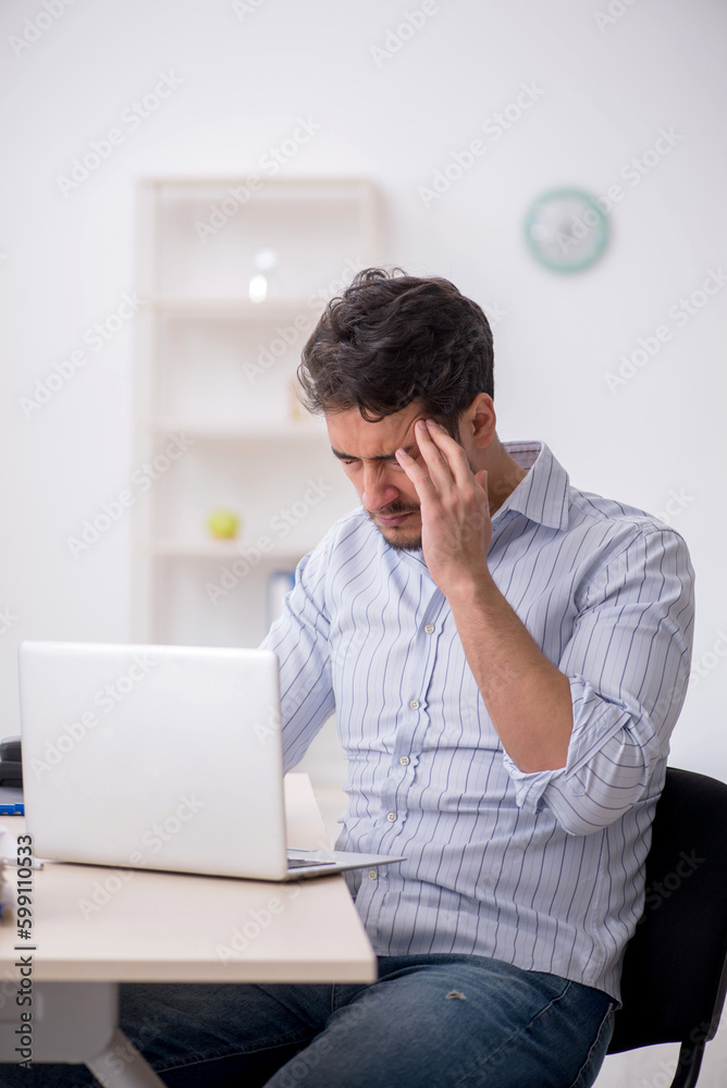Young male employee working in the office Young male employee working in the office
