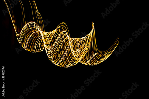 Curved lines formed by moving lights. Traces of lights in a long exposure photograph.