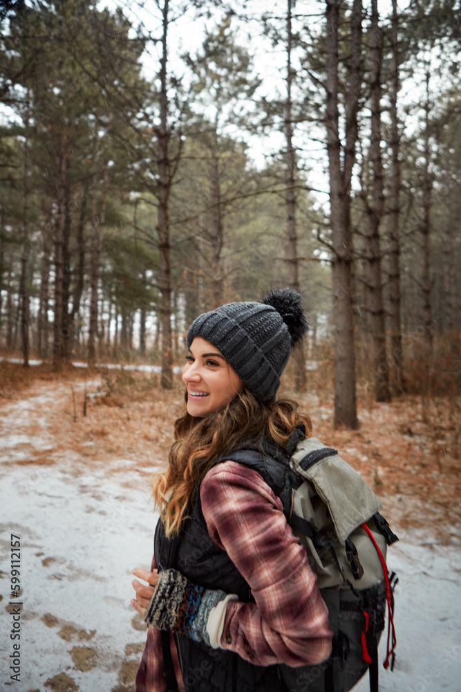 Filling her winter holiday with adventure. a young woman hiking in the wilderness during winter.