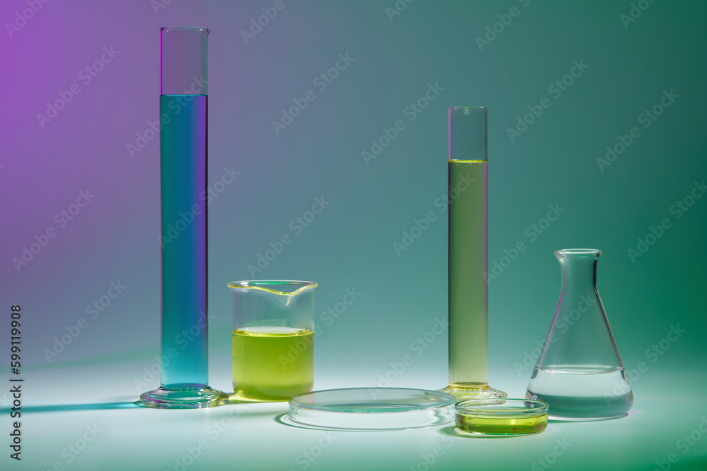 Abstract background with laboratory concept - lab glassware containing color liquid and round transparent podium for cosmetic product presentation on color background. Abstract background with laboratory concept - lab glassware containing color liquid and round transparent podium for cosmetic product presentation on color background.
