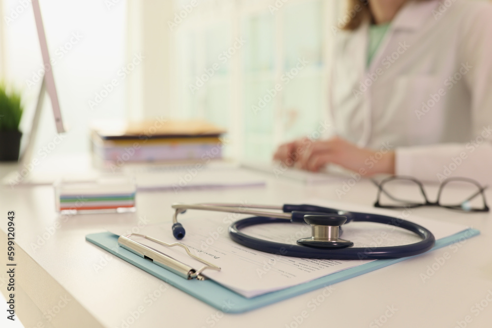 Stethoscope lies on clipboard with treatment plan on table