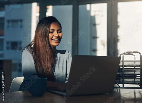 The hustle brings the dollar. a young businesswoman using a laptop in an office.