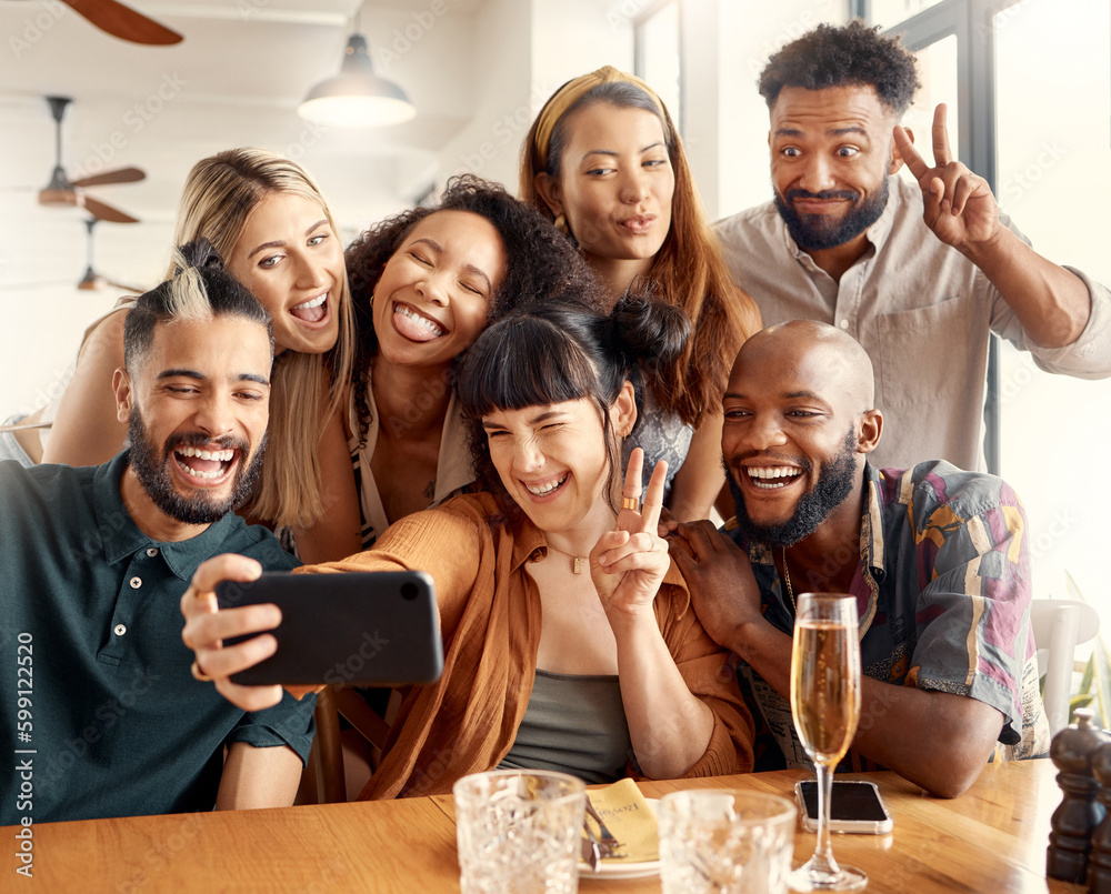 Obraz premium The best of times. a group of young friends taking selfies together at a restaurant.