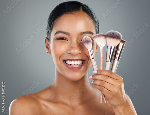 They look kinda the same but theyre really not. a beautiful young woman posing with a set of make-up brushes. photo