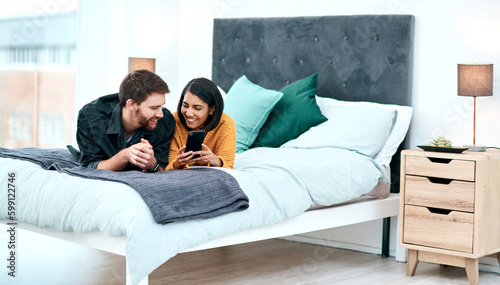 When the chemistry is real you can feel the connection. a young couple using a smartphone together on their bed at home.