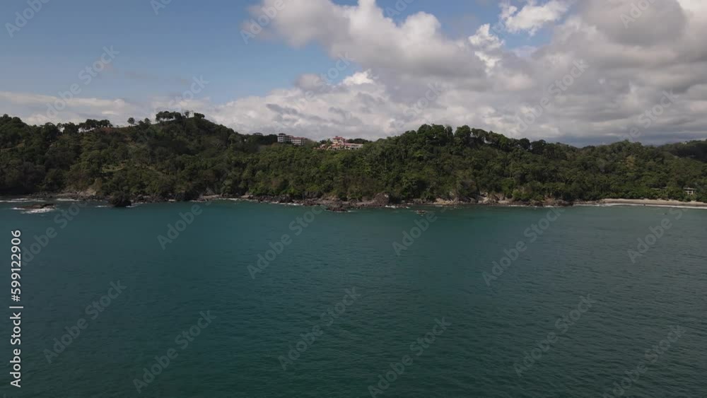 Drone view speeding from the ocean towards a luxury property