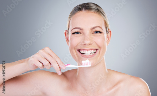 Brush twice daily to maintain your pearls. Studio portrait of an attractive mature woman brushing her teeth against a grey background.