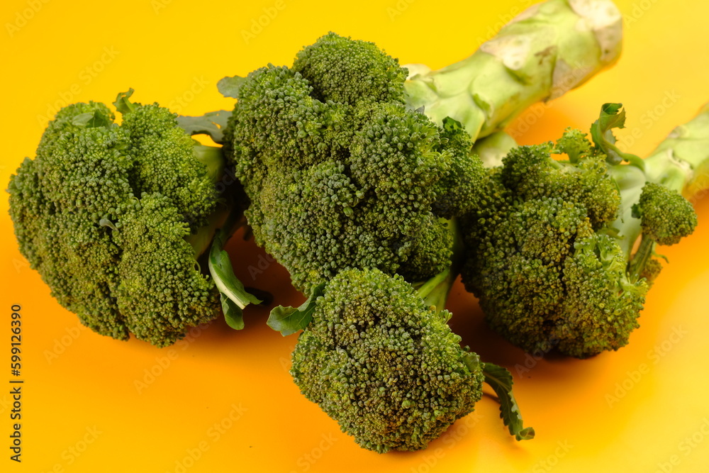 Broccoli is an edible green plant in the cabbage family. Brassica oleracea var. italica. Large head. on the yellow table. fresh broccoli. Broccoli is an edible green plant in the cabbage family. Brassica oleracea var. italica. Large head. on the yellow table. fresh broccoli.