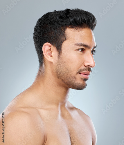 Well groomed and clean. a handsome young man posing against a grey background.