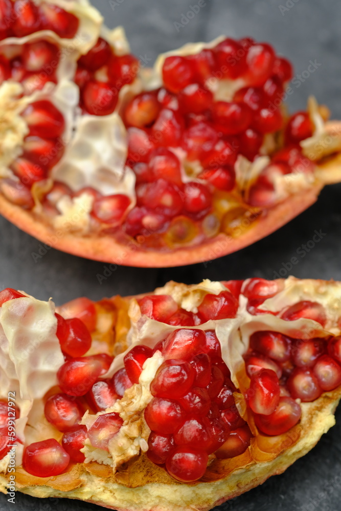 pomegranates are a staple of the diet. red pomegranate on a black table