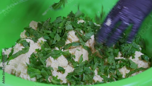 Adding fresh mint to the stuffing while making Flaouna. photo