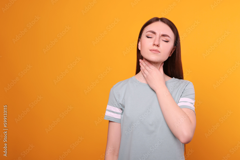 Young woman with sore throat on orange background. Space for text Young woman with sore throat on orange background. Space for text