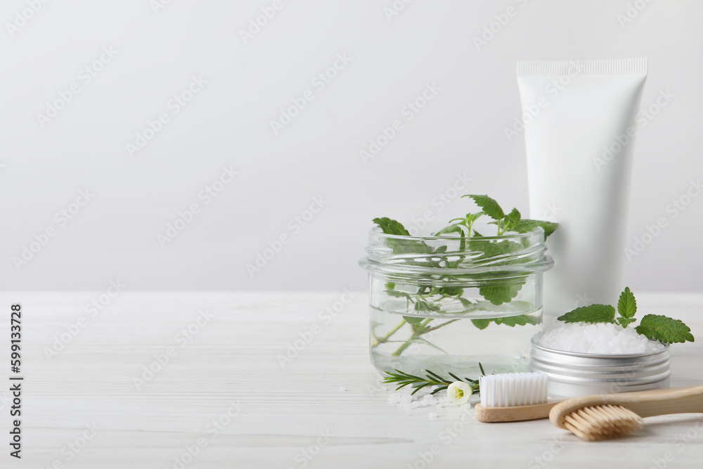 Toothbrushes, dental products and herbs on white wooden table. Space for text Toothbrushes, dental products and herbs on white wooden table. Space for text