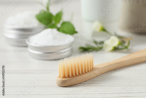 Toothbrush  dental products and herbs on white wooden table  closeup