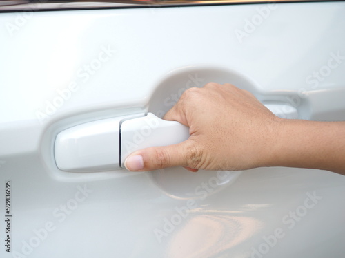 Young woman hand opening car door.