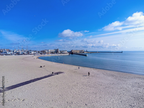 Obraz na płótnie Aerial view landscape. Urban beach in Poland, Gdynia. Photo from a drone. View of the harbor and marine. Baltic Sea. w salonie