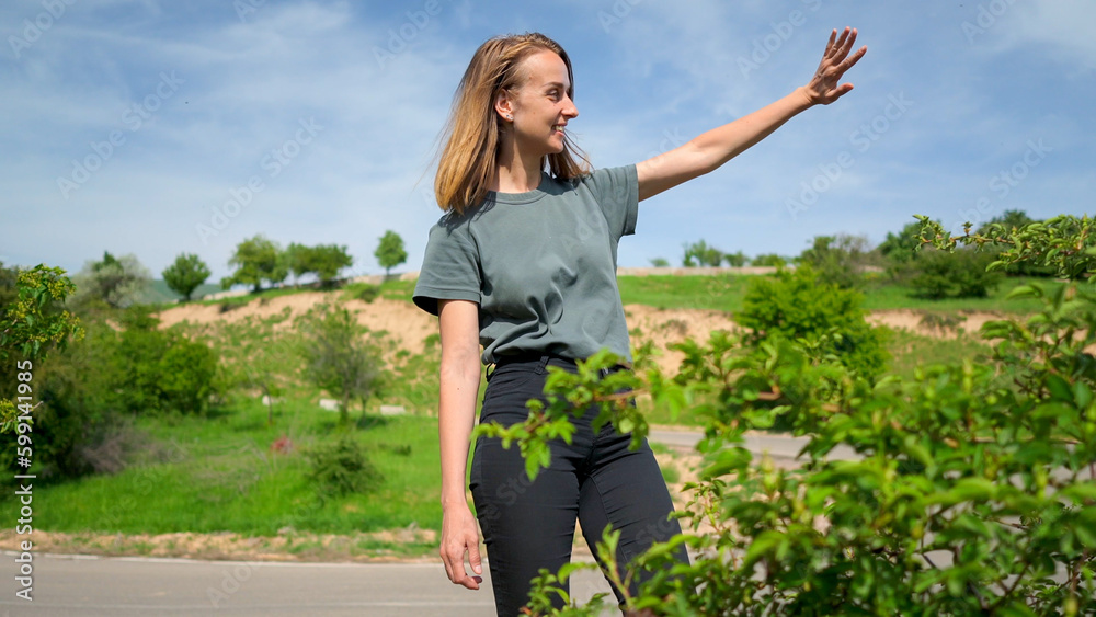 Young woman traveller greeting friends in mountain in western Tien Shan. Young woman traveller greeting friends in mountain in western Tien Shan.
