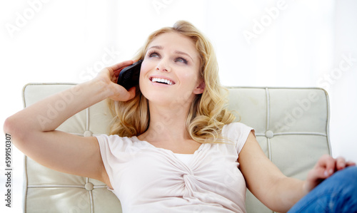 Happy woman, phone call and smile for communication or conversation while sitting in comfort at home. Female person smiling in happiness on mobile smartphone for friendly discussion on lounge chair