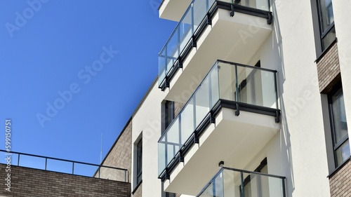 Modern apartment buildings on a sunny day with a blue sky. Facade of a modern apartment building. Contemporary residential building exterior in the daylight.  © Grand Warszawski