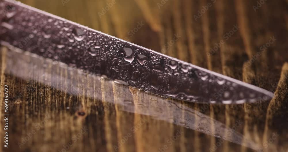 a sharp little knife covered with water drops, a small knife in water drops on a wooden table a sharp little knife covered with water drops, a small knife in water drops on a wooden table