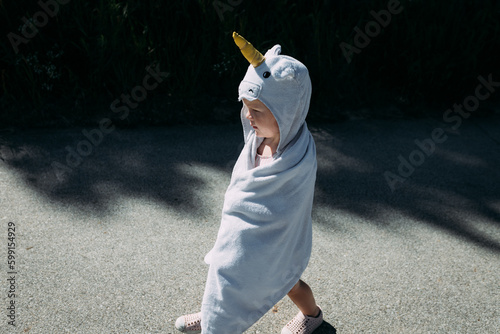 Child wrapped in unicorn towel after swimming