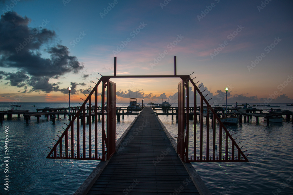 Dock with boats and sailboats on a beach in Aruba, at sunset, Ne