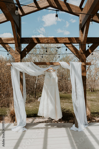 Wedding Dress hanging from the ceremony arbour in spring