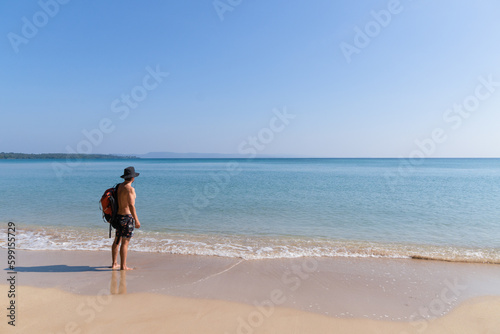 backpacker with his backpack on lonely beach