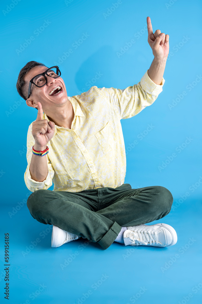 Man with eyeglasses and a shirt wearing a rainbow bracelet pointing at something Man with eyeglasses and a shirt wearing a rainbow bracelet pointing at something