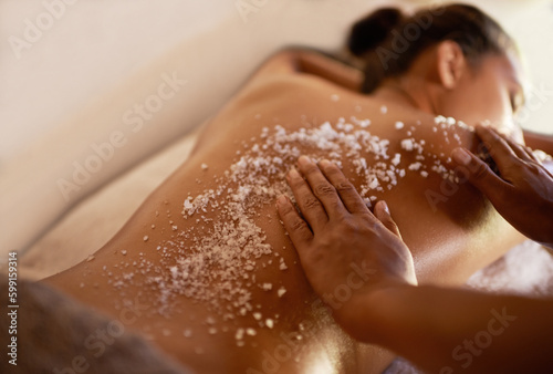 Spa scrub, skincare and body massage of a woman with beauty specialist with salt treatment. Exfoliate, female person back and relax detox application for skin and calm wellbeing at a hotel with care