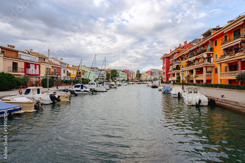 Walk through the streets and canals of the port of Saplaya on a sunny day. Moored yachts and boats at the bright facades of houses. Spain © victorgrow