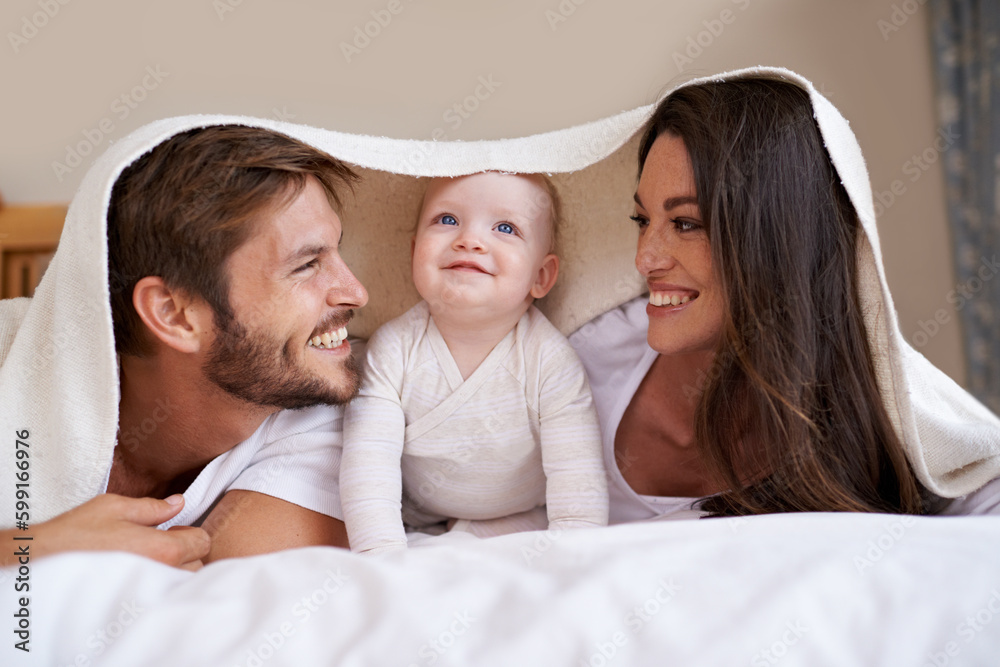 Happy family, parents and baby with blanket on bed for love, care and quality time together. Mother, father and playful newborn child relaxing in bedroom with bedding fort, smile and bonding at home Happy family, parents and baby with blanket on bed for love, care and quality time together. Mother, father and playful newborn child relaxing in bedroom with bedding fort, smile and bonding at home