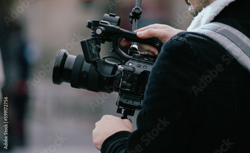 The operator stands with a video camera