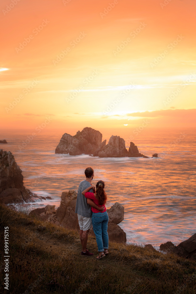 Beautiful sunset as a couple from the cliffs of the Costa Quebrada in Los Urros de Liencres, Cantabria Spain