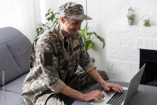 Cropped shot of a mid adult male soldier looking thoughtful while working on his laptop