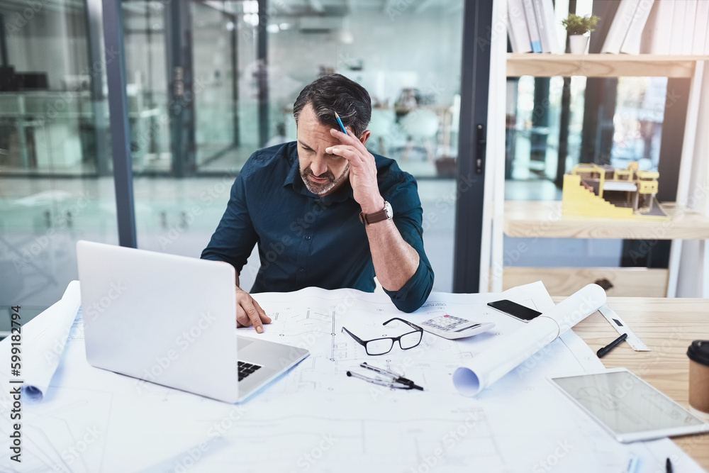 Architects are dreamers and doers. a mature male architect using his laptop. Architects are dreamers and doers. a mature male architect using his laptop.