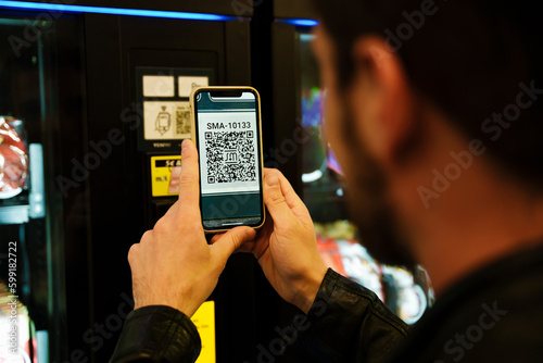 Bilde på lerret Man scanning qr code while standing in subway