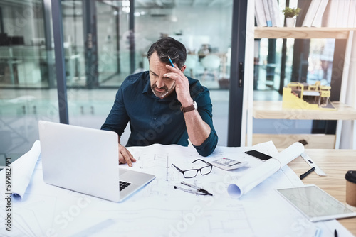 Architects are dreamers and doers. a mature male architect using his laptop.