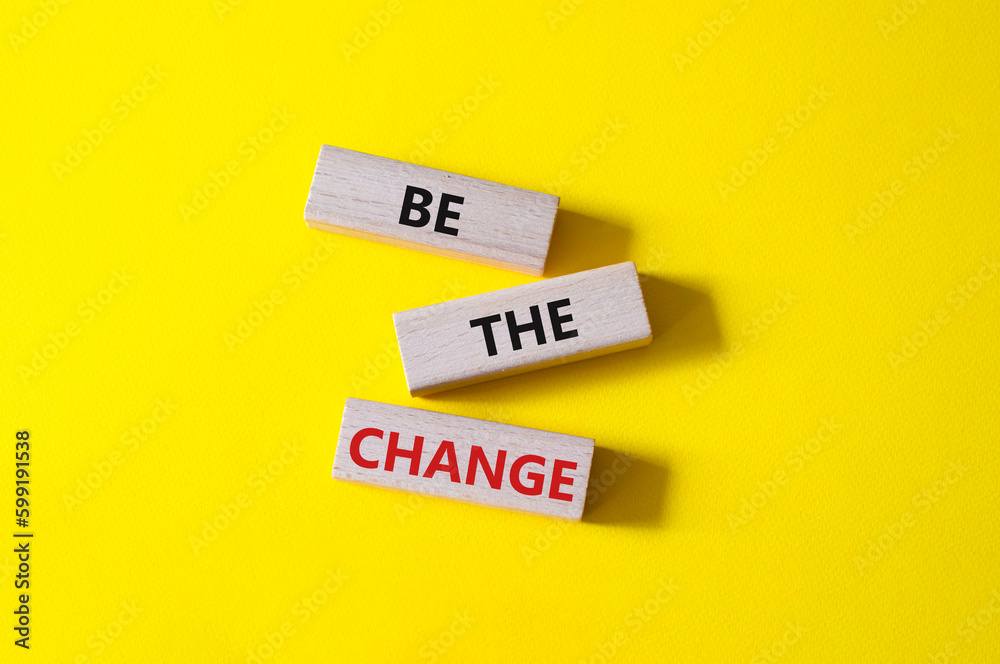 Naklejka premium Be the change symbol. Concept word Be the change on wooden blocks. Beautiful yellow background. Business and Be the change concept. Copy space